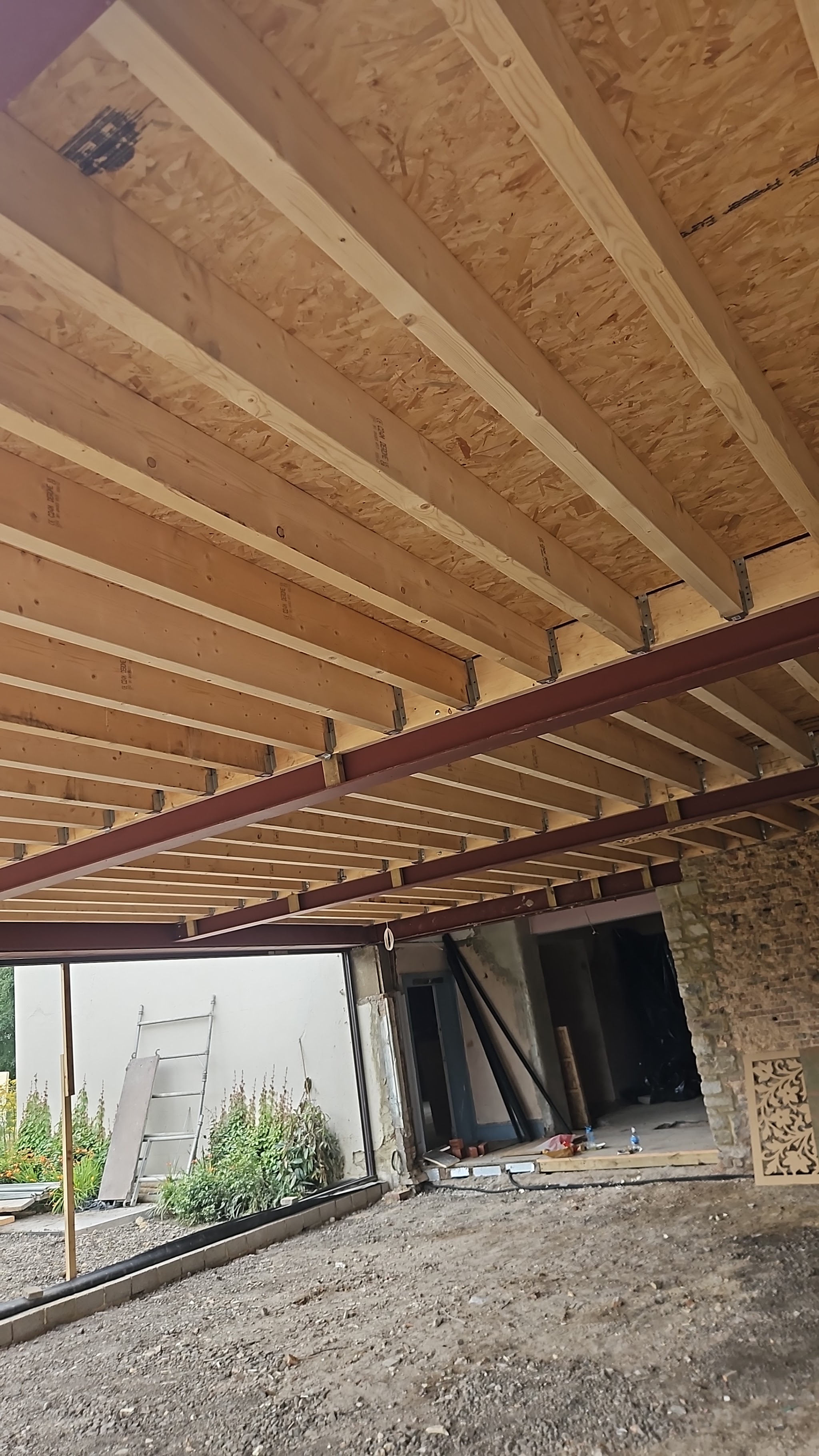 Timber joists and a steel beam seen from below on an extension